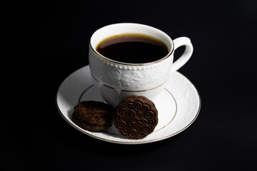 Porcelain cup of tea with tea and biscuit isolated on black background, cliping path