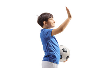Profile shot of a football boy with a soccer ball gesturing high five