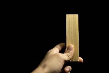Board in hand. Bar made of wood. Blank in hand of carpenter.