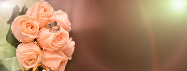 A beautiful bouquet of peach roses in close-up. Rose is wearing two wedding rings. Wedding. The wedding. selective focus