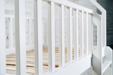The image of the child's bed, illuminated by studio fixtures. Beautiful crib railing, lattice.