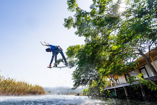 Kiteboarder in action jumping in the air doing extreme tricks, Akyaka, Turkey