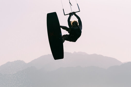 Silhouette of kiteboarder in the air doing extreme move, Dahab, Egypt
