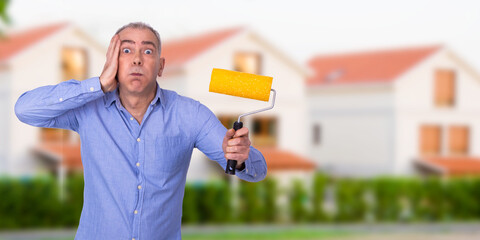 man with paint brush and houses background