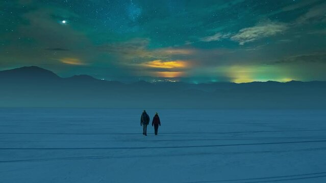 The two travelers walking through the night snow field