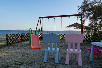 Two children chairs on the children playground by the sea
