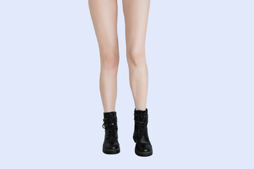 Slender legs of caucasian woman in black boots. White isolate.