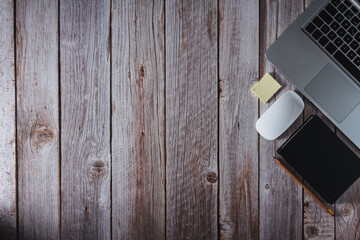 Workspace with laptop, notebook and pencil on wooden background. Top view. Copy space. Selective focus.