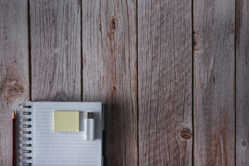 Notebook with pen, notes and USB flash drive on wooden background. Top view. Copy space. Selective focus.