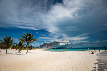 A cruise ship docked right next to tropical island beach in Bahamas