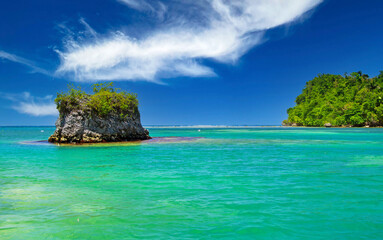 Beautiful caribbean landscape with secluded turquoise reef lagoon, rock, clear blue sky - Port Antonio, San San beach, Jamaica