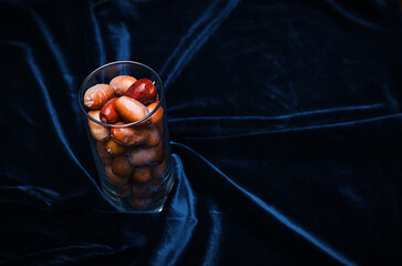 Background photo of dates. Dates in a glass on a blue background. - obrazy, fototapety, plakaty