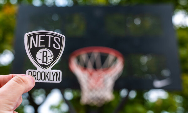 September 15, 2021, New York, USA, A man holds the logo of the Brooklyn Nets basketball club in his hand on the sports ground.