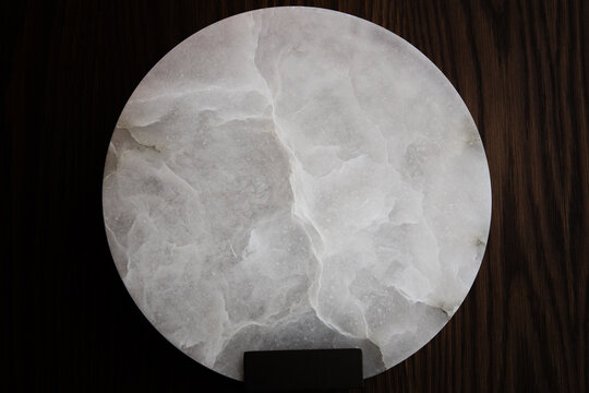 natural textured for a Round piece of white onyx marble fixed on a wooden wall