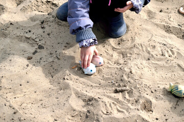 Ukraine. A child plays in the sand between air raids sirens