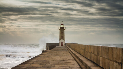 Lighthouse in Porto, Portugal, on a stormy day and big waves.