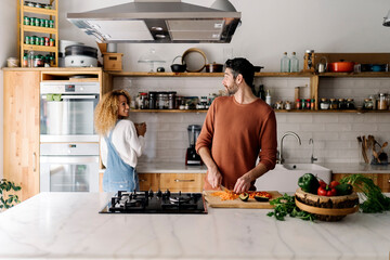 Couple preparing food in kitchen.