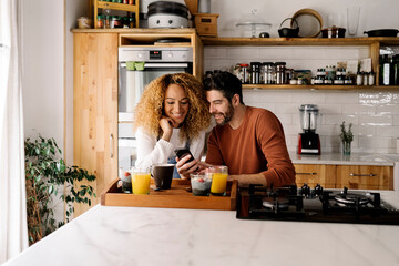 Couple having breakfast in kitchen.