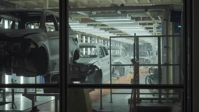 The car frame moves along the conveyor belt.