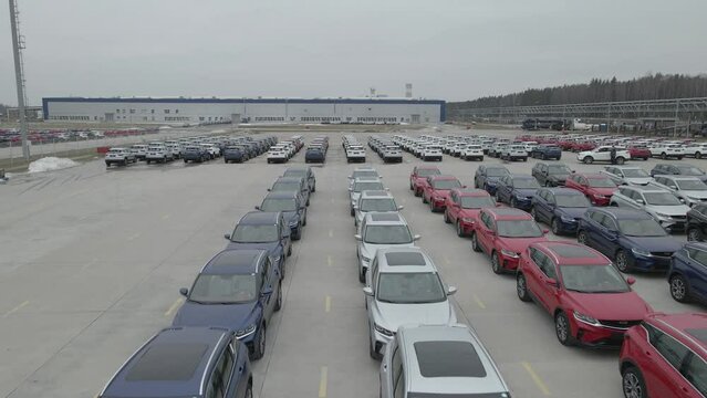 The new cars are lined up in the parking lot outside the production facility.