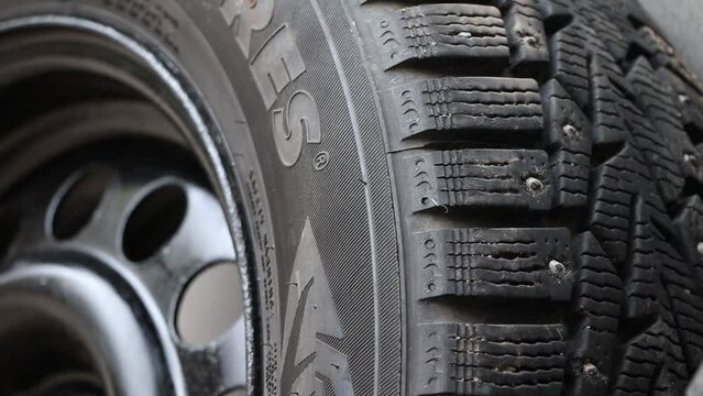 Used winter studded tire for car.Studded wheel for car close-up.