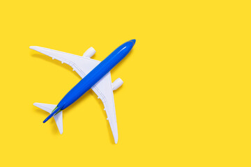 Aircraft model on a yellow background with free space for text or advertising. Tourism or freight transport concept. Toy airplane on a red background with a top view
