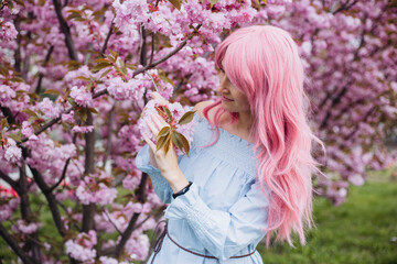 woman near pink sakura blooming tree