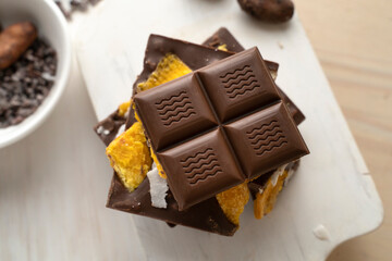 Raw Vegan Handmade Chocolate with dried mango fruits and coconuts slices close up. Chocolate bar with mango on a light background