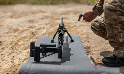 Modern sniper rifle on bipods. Discharged sniper weapon in combat position. Light back.