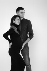 Husband hugs pregnant wife and touching belly