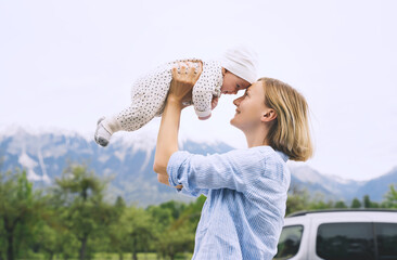 Mother and baby walking on nature outdoors. Family in green nature background. Loving woman with...