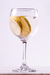 gin tonic glass with lemon slices on white background