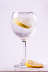 gin tonic glass with lemon slices on white background