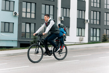Naklejka na ściany i meble father riding bike with son in bike seat