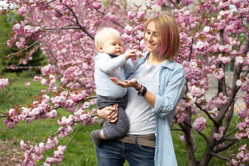 Mother with little son playing in the park the sakura tree