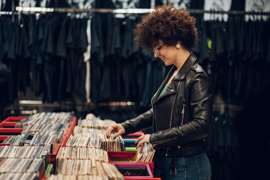 Woman with afro hair browsing vinyl records in a record store
