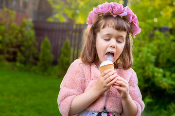 Adorable little girl wearing flower crown and eating tasty fresh ice cream - 502481827