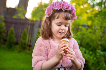Adorable little girl wearing flower crown and eating tasty fresh ice cream - 502481833