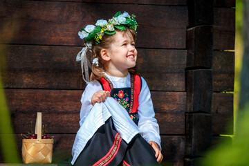 Adorable little girl in Swedish traditional clothes during Midsommar festival - 502481837