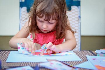Cute little girl playing on paper art origami. Children being creative, developing imagination, creativity