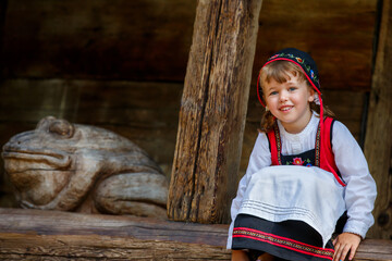 Adorable little girl in Swedish traditional clothes during Midsommar festival - 502481844