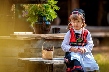 Adorable little girl in Swedish traditional clothes during Midsommar festival - 502481849