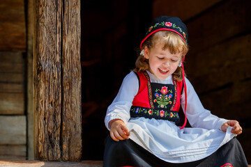 Adorable little girl in Swedish traditional clothes during Midsommar festival - 502481855