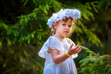 Adorable little girl wearing flower crown and walking outdoors - 502481856
