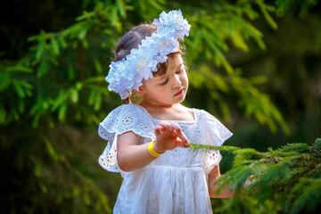 Adorable little girl wearing flower crown and walking outdoors - 502481858