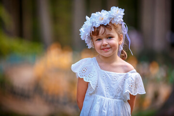 Adorable little girl wearing flower crown and walking outdoors - 502481861