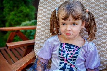 Portrait of cute happy little girl sitting outdoors - 502481862
