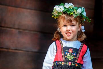 Adorable little girl in Swedish traditional clothes during Midsommar festival - 502481870