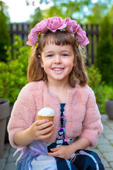 Adorable little girl wearing flower crown and eating tasty fresh ice cream - 502481872