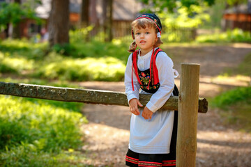 Adorable little girl in Swedish traditional clothes during Midsommar festival - 502481874